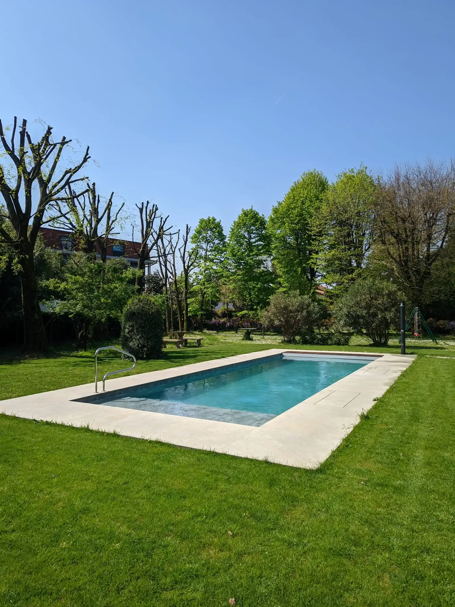 Piscina con spiaggia e copertura a tapparella